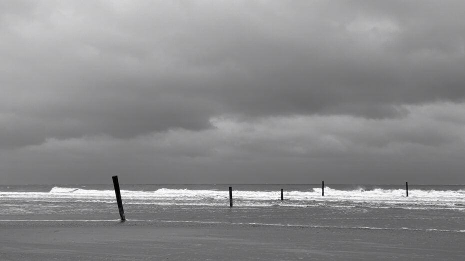 Pfähle, die in die Nordsee reinlaufen