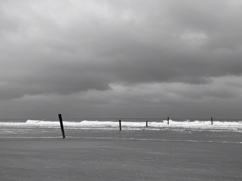 Pfähle, die in die Nordsee reinlaufen