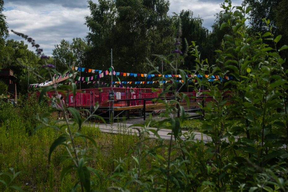 Familienfest auf einer aus Gitterrohren gebauten Tanzterasse umgarnt von bunten Fähnchen