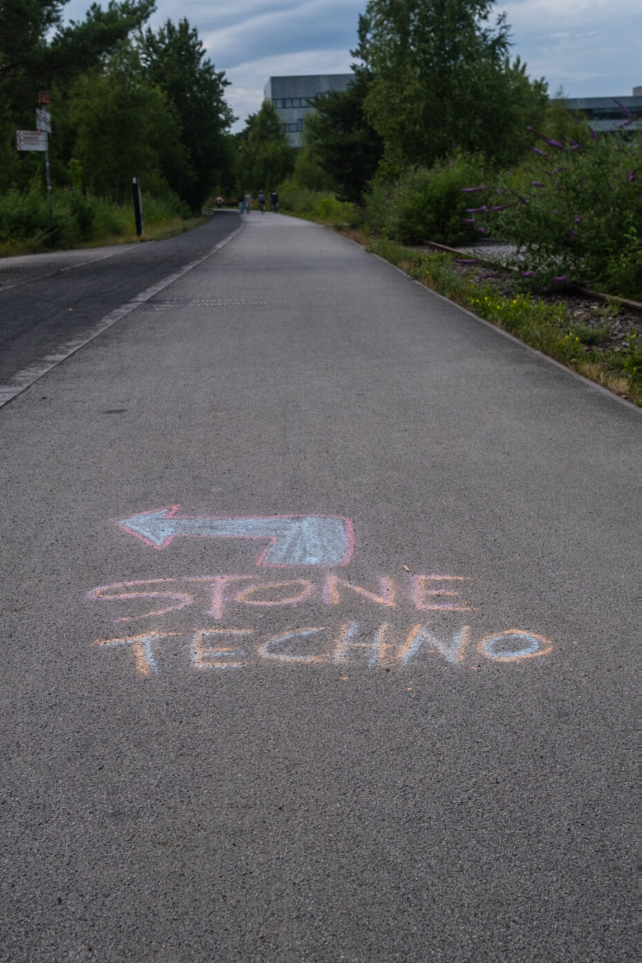 Wegweiser auf Straßenmalkreide auf einem asphaltierten Radweg zum Stone Techno