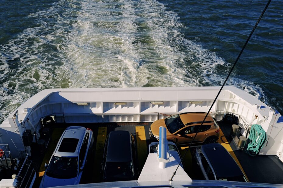 Blick auf das Heck einer offenen Fähre, ein Auto parkt quer am Ende der Ladezone